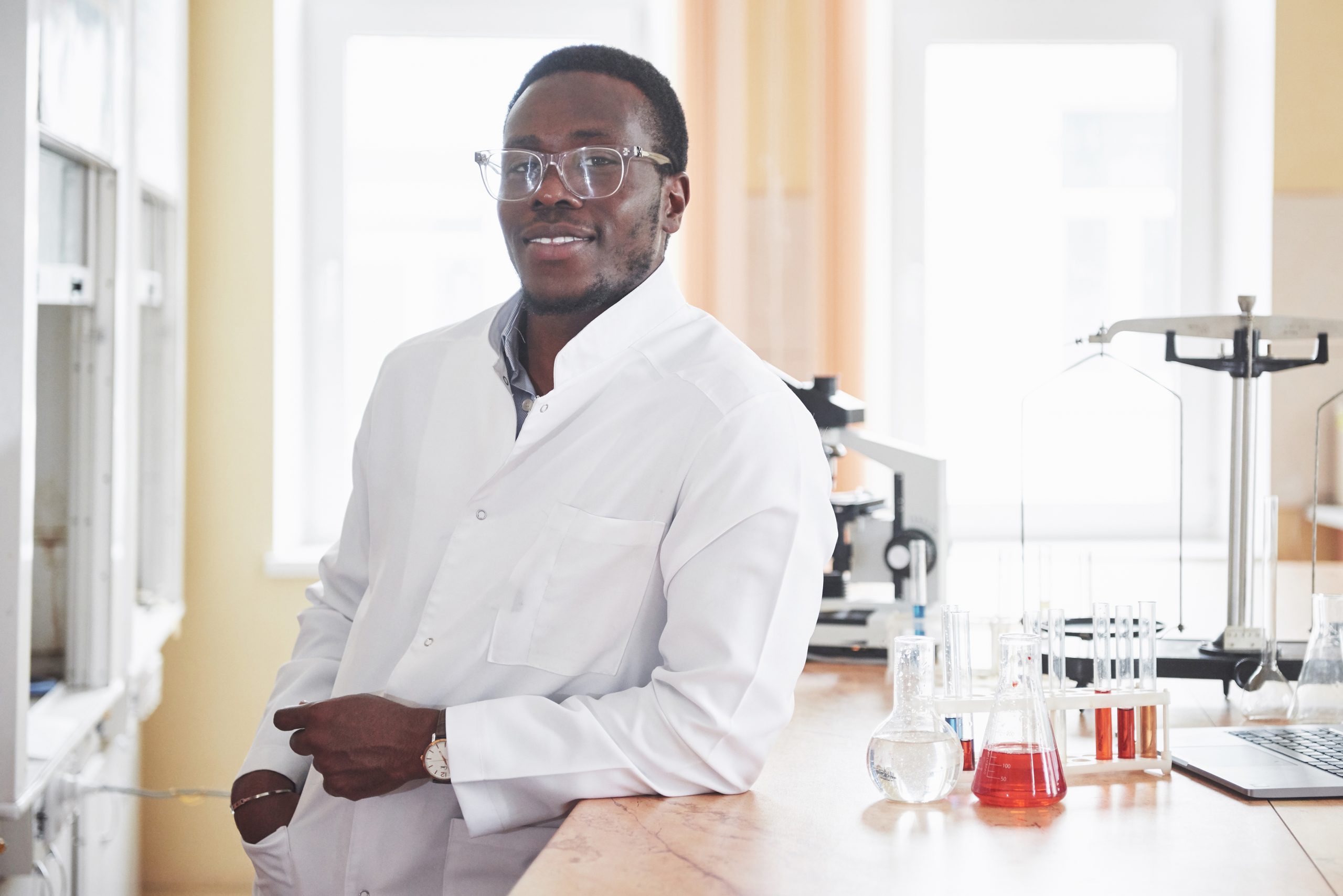 an african american worker works in a laboratory conducting experiments.